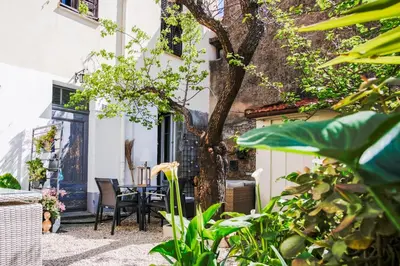 a patio with a table and chairs and a tree at Appartement très cosy avec cour in Cannes