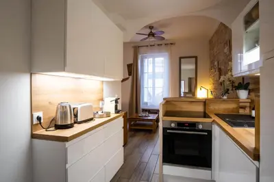 a kitchen with white cabinets and a counter top at Appartement très cosy avec cour in Cannes