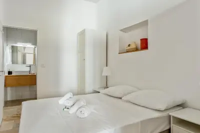 a white bedroom with a bed with towels on it at Appartement Immaculia - Welkeys in Cannes