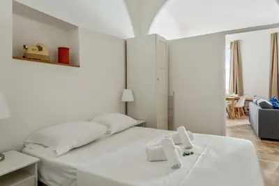 a white bedroom with a bed with towels on it at Appartement Immaculia - Welkeys in Cannes