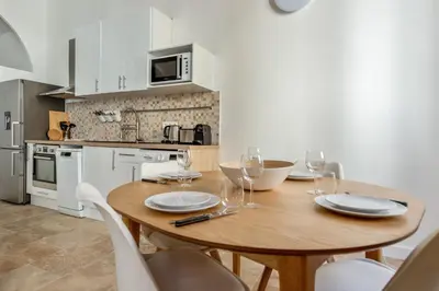 a kitchen with a wooden table with wine glasses at Appartement Immaculia - Welkeys in Cannes
