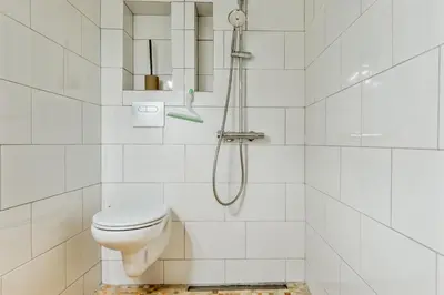 a white bathroom with a shower and a toilet at Appartement Immaculia - Welkeys in Cannes