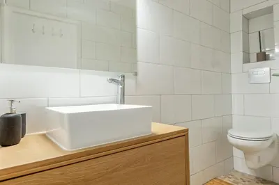 a white bathroom with a sink and a toilet at Appartement Immaculia - Welkeys in Cannes