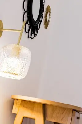 a table with a mirror and a lamp on a wall at Luxury 3 Bd Aptment with Sea view in Cannes