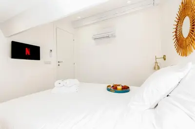 a white bedroom with a bed with a bowl of fruit on it at Luxury 3 Bd Aptment with Sea view in Cannes