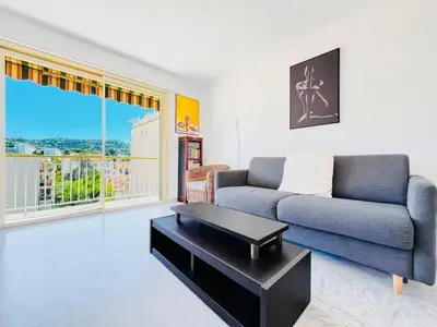 a living room with a couch and a table at L'Oasis - 3 Pièces centre Cannes in Cannes