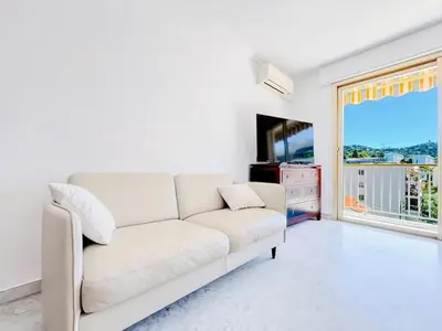 a white living room with a white couch and a window at L'Oasis - 3 Pièces centre Cannes in Cannes
