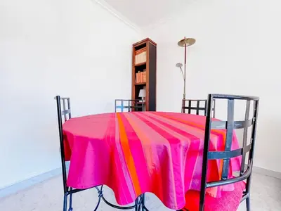 a room with a table with a pink table cloth at L'Oasis - 3 Pièces centre Cannes in Cannes