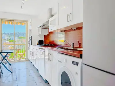 a white kitchen with a sink and a dishwasher at L'Oasis - 3 Pièces centre Cannes in Cannes