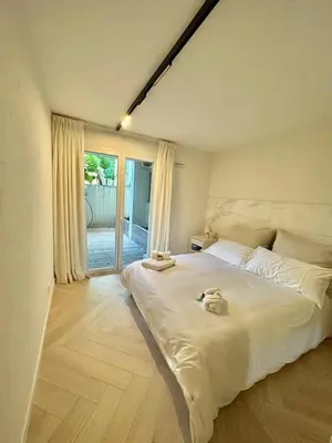 a bedroom with a large white bed and a window at CAM0 - appartement 2 chambres en rez-de-terrasse in Cannes