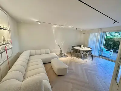 a living room with a white couch and a table at CAM0 - appartement 2 chambres en rez-de-terrasse in Cannes