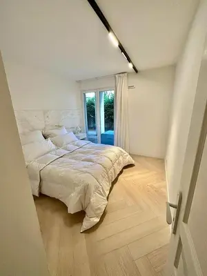 a white bedroom with a large bed and a window at CAM0 - appartement 2 chambres en rez-de-terrasse in Cannes