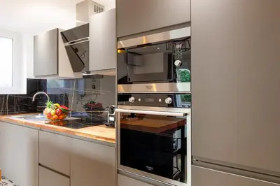a kitchen with a stove and a microwave at Cyclades YourHostHelper in Cannes