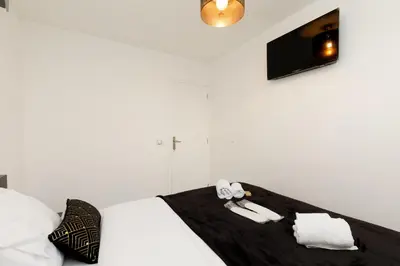 a white bedroom with a bed with two towels on it at Cyclades YourHostHelper in Cannes