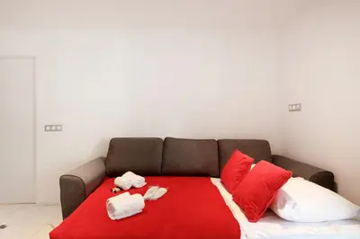 a couch with stuffed animals on a red blanket at Cyclades YourHostHelper in Cannes