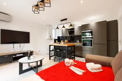 a living room with a couch and a red rug at Cyclades YourHostHelper in Cannes