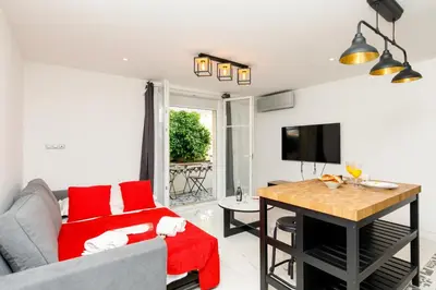 a living room with a couch and a table at Cyclades YourHostHelper in Cannes