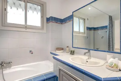 a bathroom with a tub and a sink and a mirror at Le Vautrin - Charmant Appartement à 300 mètres des plages de la Croisette in Cannes