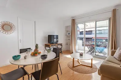 a living room with a table and a couch at Le Vautrin - Charmant Appartement à 300 mètres des plages de la Croisette in Cannes
