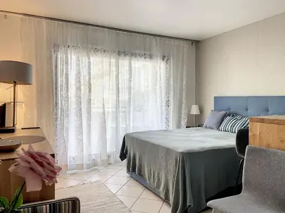 a bedroom with a bed and a large window at Cannes - Studio en plein cœur de Cannes in Cannes