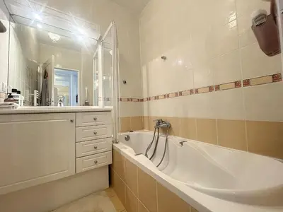 a bathroom with a tub and a sink and a mirror at Cannes - Studio en plein cœur de Cannes in Cannes