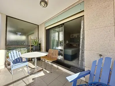 a balcony with a table and chairs and a bathroom at Cannes - Studio en plein cœur de Cannes in Cannes