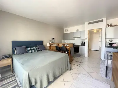 a bedroom with a large bed and a kitchen at Cannes - Studio en plein cœur de Cannes in Cannes