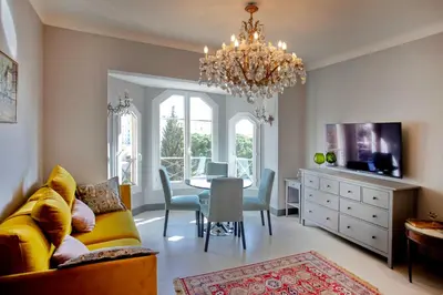 a living room with a yellow couch and a dining room at Appartement 5 min des plages Croisette in Cannes