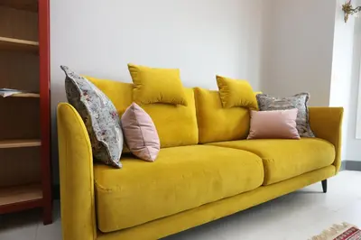a yellow couch with pillows on it in a room at Appartement 5 min des plages Croisette in Cannes