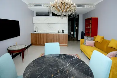 a living room with a table and a yellow couch at Appartement 5 min des plages Croisette in Cannes