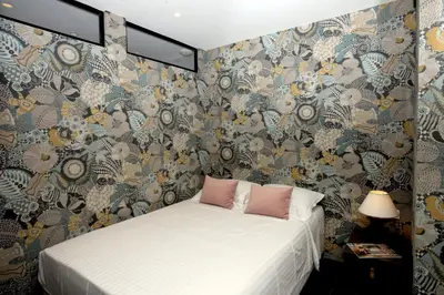 a bedroom with a bed and a floral wallpaper at Appartement 5 min des plages Croisette in Cannes