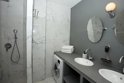 a bathroom with a shower and a sink and a washing machine at Appartement 5 min des plages Croisette in Cannes