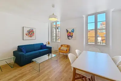 a living room with a blue couch and a table at HENRI CAMILLE REAL ESTATE - Bambou- One bedroom apt downtown in Cannes