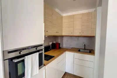 a small kitchen with white cabinets and a sink at HENRI CAMILLE REAL ESTATE - Bambou- One bedroom apt downtown in Cannes