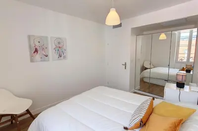 a white bedroom with a bed and a mirror at HENRI CAMILLE REAL ESTATE - Bambou- One bedroom apt downtown in Cannes