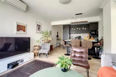 a living room with a large television and a kitchen at HENRI CAMILLE REAL ESTATE- Santiago - 2 bedrooms close Croisette in Cannes