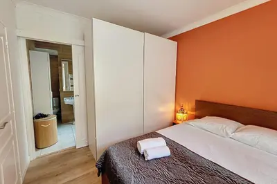 a bedroom with a bed with an orange wall at HENRI CAMILLE REAL ESTATE- Santiago - 2 bedrooms close Croisette in Cannes