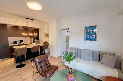a living room with a couch and a kitchen at HENRI CAMILLE REAL ESTATE- Santiago - 2 bedrooms close Croisette in Cannes