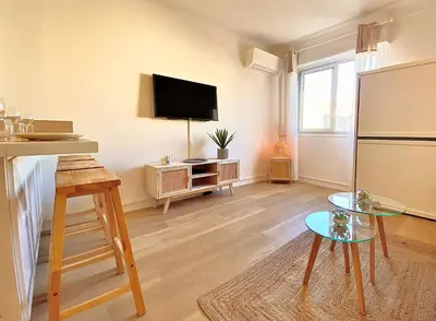 a living room with a refrigerator and a tv at PACA Properties 57A - Studio cosy in Cannes