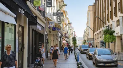 people walking down a street in a city with cars at PACA Properties 57A - Studio cosy in Cannes