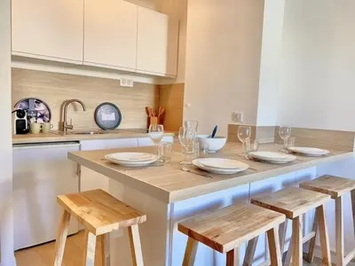 a kitchen with a table with chairs and wine glasses at PACA Properties 57A - Studio cosy in Cannes
