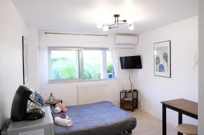a bedroom with a blue bed and a table at Studio centre de Cannes in Cannes