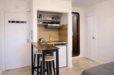 a small kitchen with a table and stools in a room at Studio centre de Cannes in Cannes