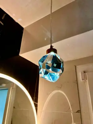 a blue glass pendant light hanging from a ceiling at Palais 5min Luxury&Cinema Studio in Cannes