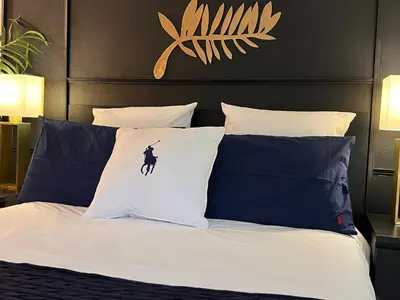 a bedroom with a bed with blue and white pillows at Palais 5min Luxury&Cinema Studio in Cannes