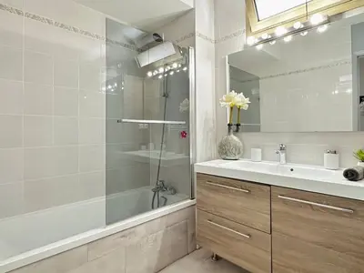 a bathroom with a shower and a sink and a mirror at L'Azur - Appartement 2 chambres - Terrasse in Cannes