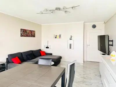 a living room with a couch and a table at L'Azur - Appartement 2 chambres - Terrasse in Cannes