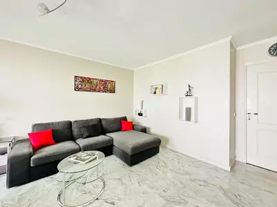 a living room with a black couch and red pillows at L'Azur - Appartement 2 chambres - Terrasse in Cannes