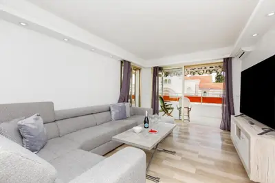 a living room with a couch and a tv at Les Liserons YourHostHelper in Cannes