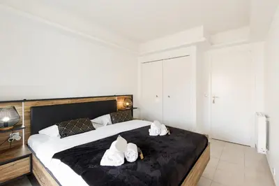 a bedroom with a large bed with white shoes on it at Les Liserons YourHostHelper in Cannes
